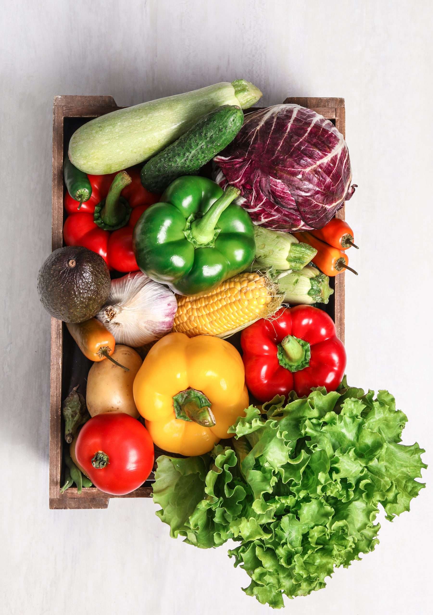 Crate with different fresh vegetables on light background, top v